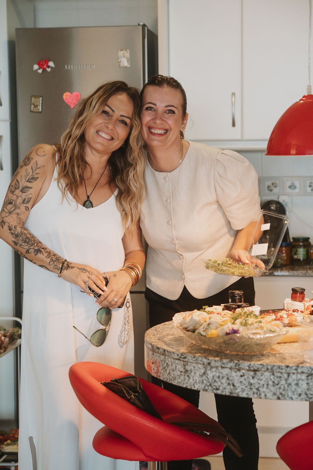 Angelika and a guest smiling together in the kitchen