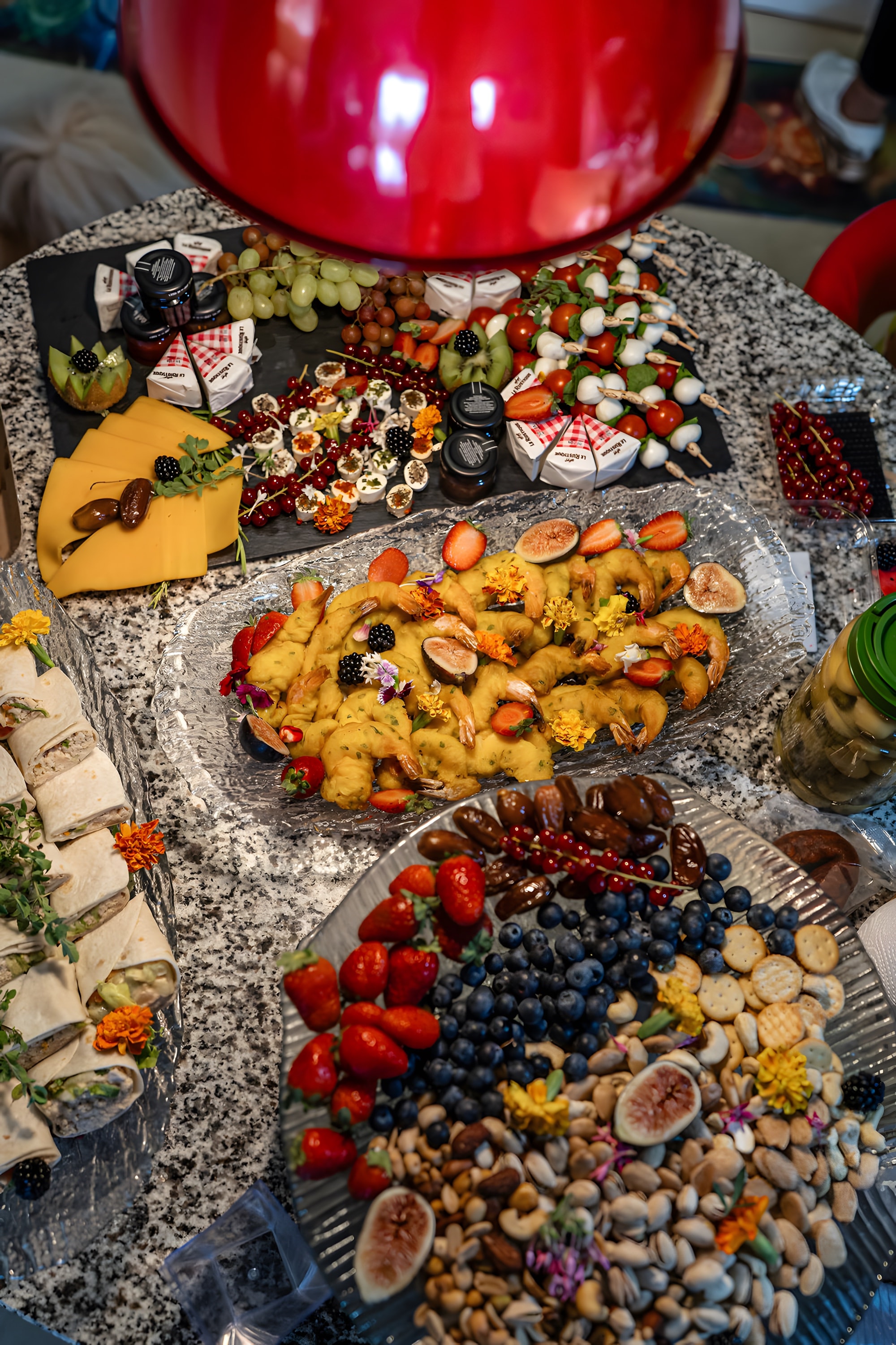 Several grazing platters of fruit, cheese and canapés seen from above