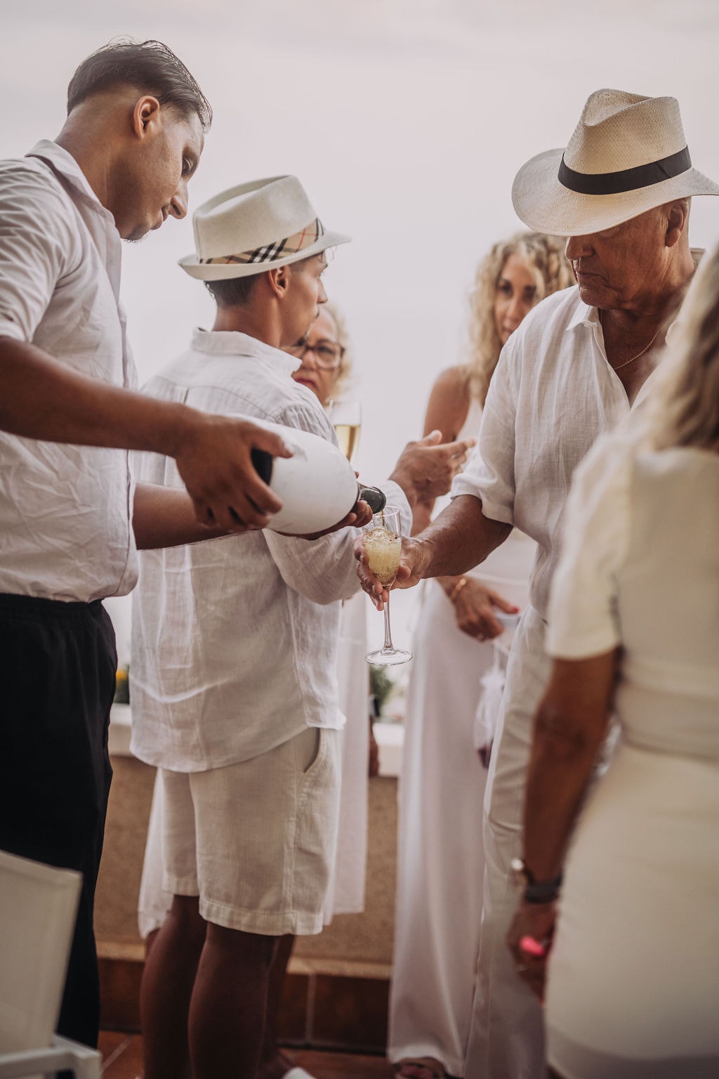 Champagne being poured for guests dressed in white on the terrace
