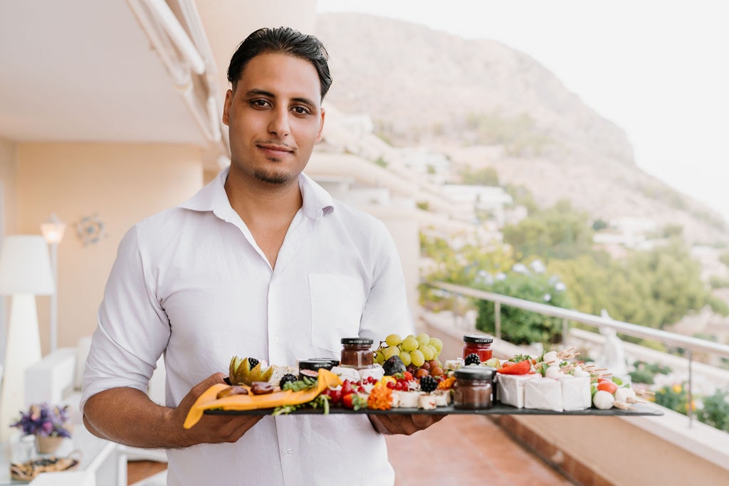 A member of the Creativa team carrying a tray of canapés on the terrace