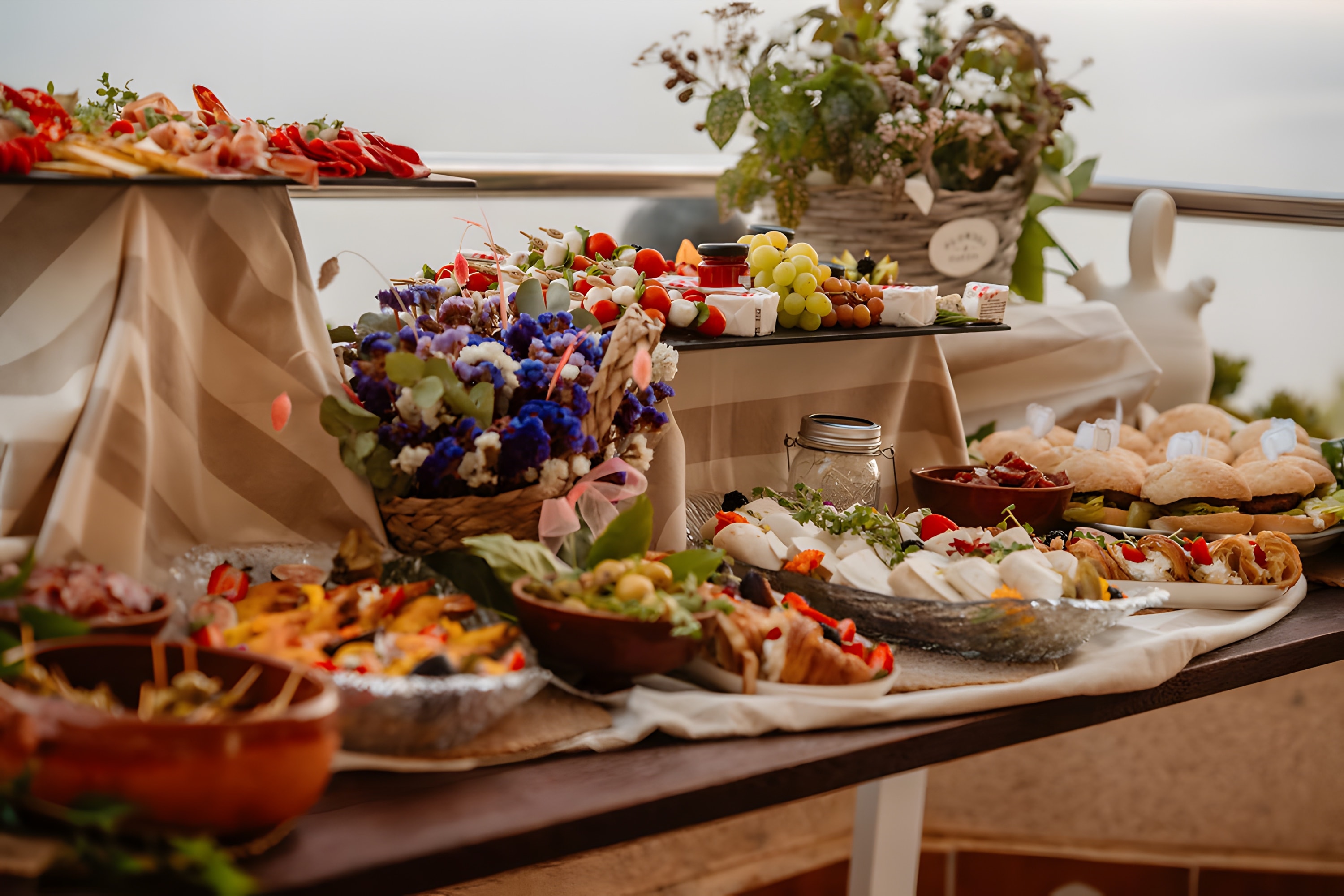 Purple flowers and colourful platters on a terrace table at dusk