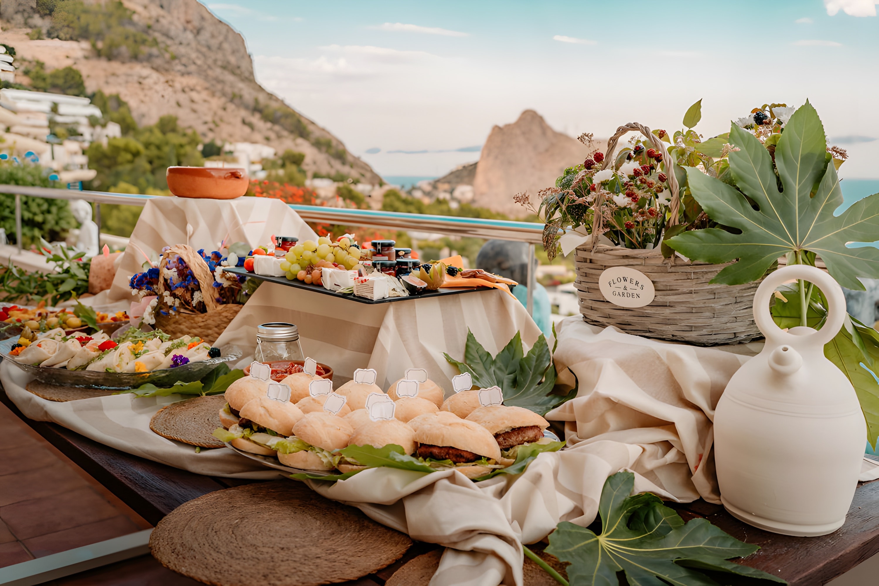 Platters, flowers and linen on a terrace table facing the Costa Blanca coast